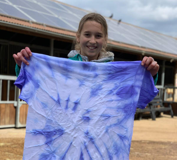 Child shows tie-dyed t-shirt